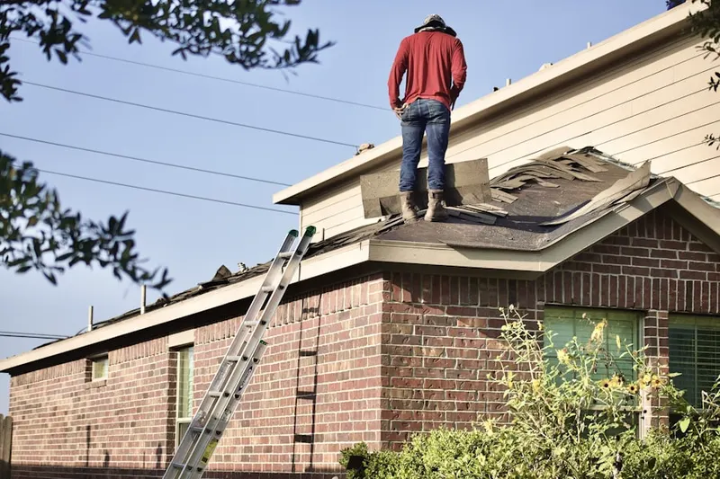 Professional roofer working on a residential roof in Hayes Crossing
